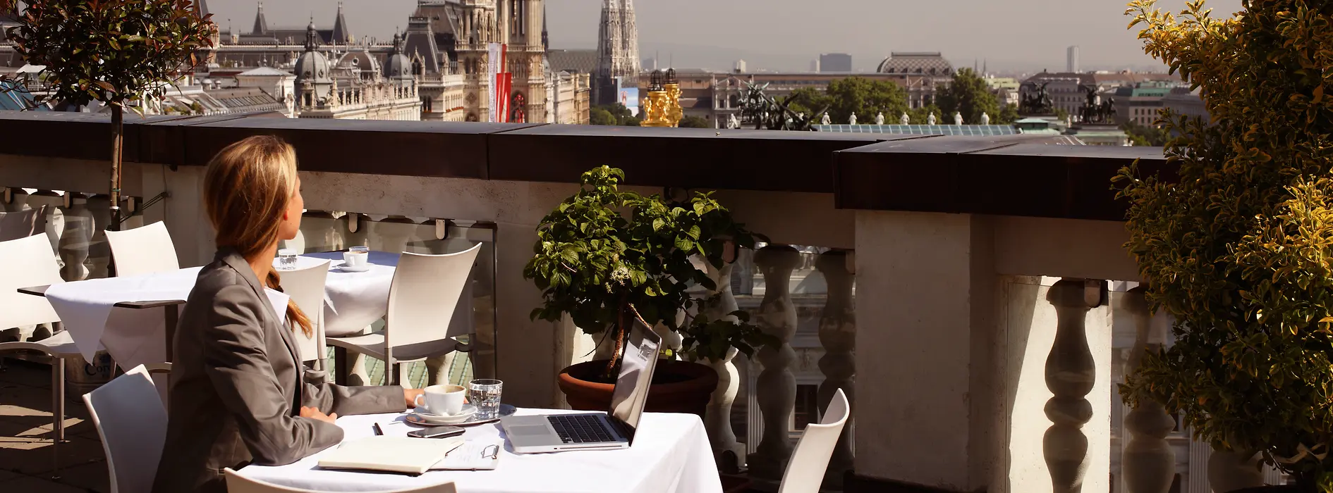 Woman at a coffeehouse with laptop and cell phone