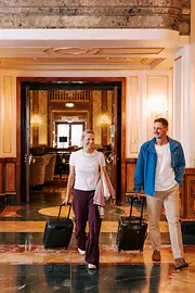 Two people with luggage in a Viennese hotel