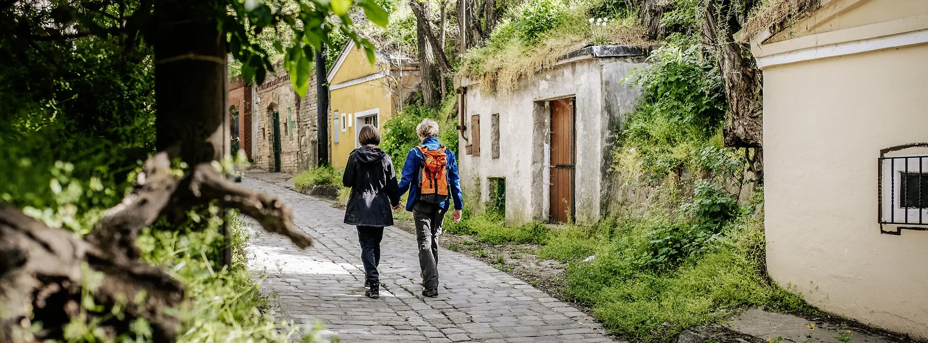 Two women walk past wine cellars