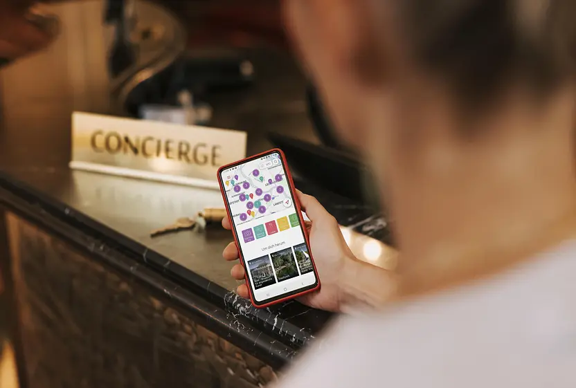 A man is standing in front of reception, with the ivie app open on his cell phone