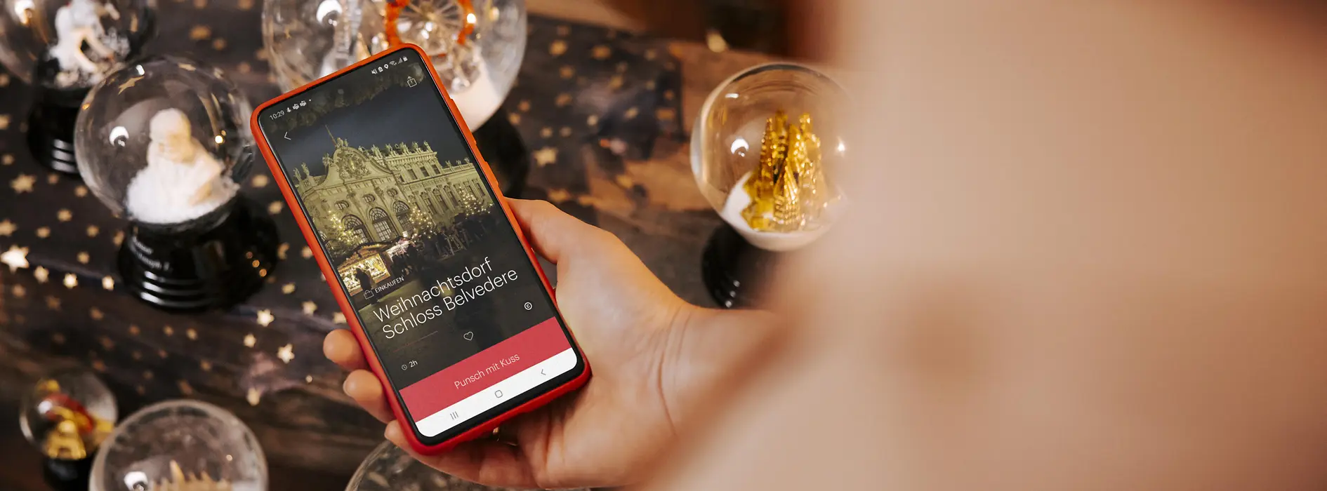 Smart phone with view from ivie, surrounded by snow globes