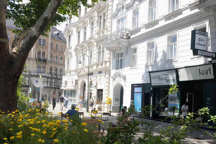 Street scene with a green park area and benches at Margaretenplatz in Vienna