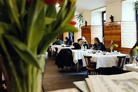Interior view of the restaurant "Rebhuhn" with guests at the tables