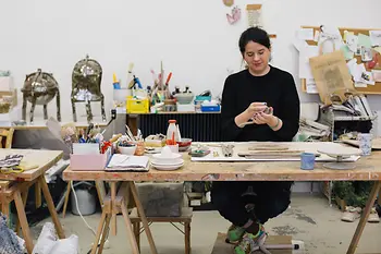 Onka Allmayer-Beck modeling clay at the table in her studio