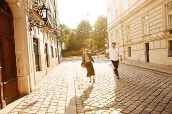 Couple walking in the old town, green area in the background