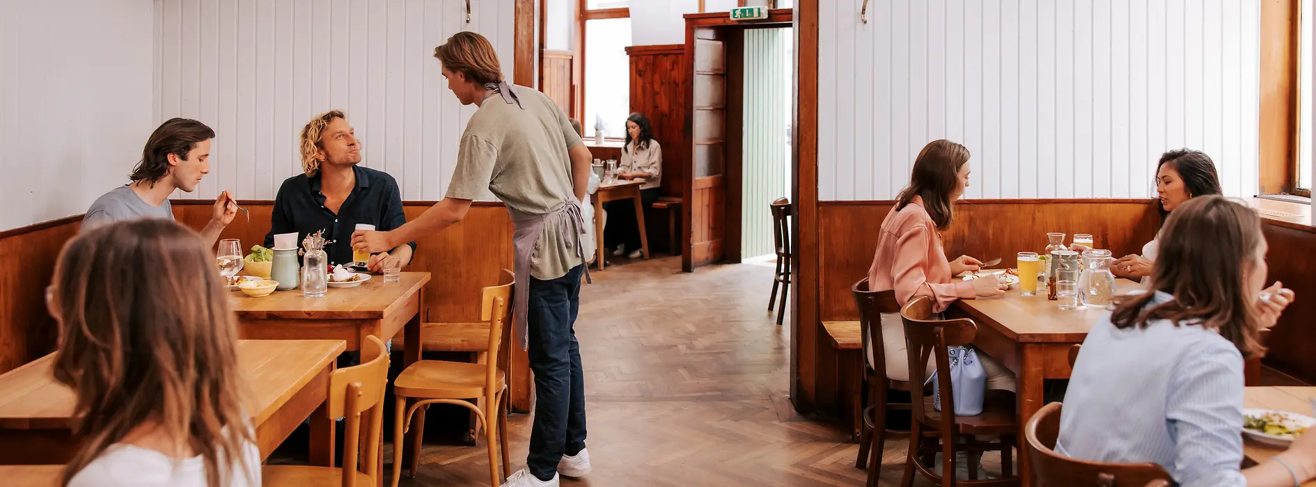 Interior view of the Brösl restaurant in the Stuwerviertel, guests being served