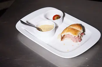 half-eaten "Leberkäse" meatloaf roll on a plate